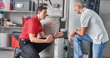HVAC installer discussing heating services with a homeowner